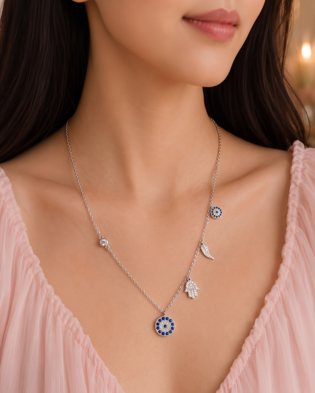 Sterling silver charm necklace featuring evil eye, hamsa hand and other luck charms