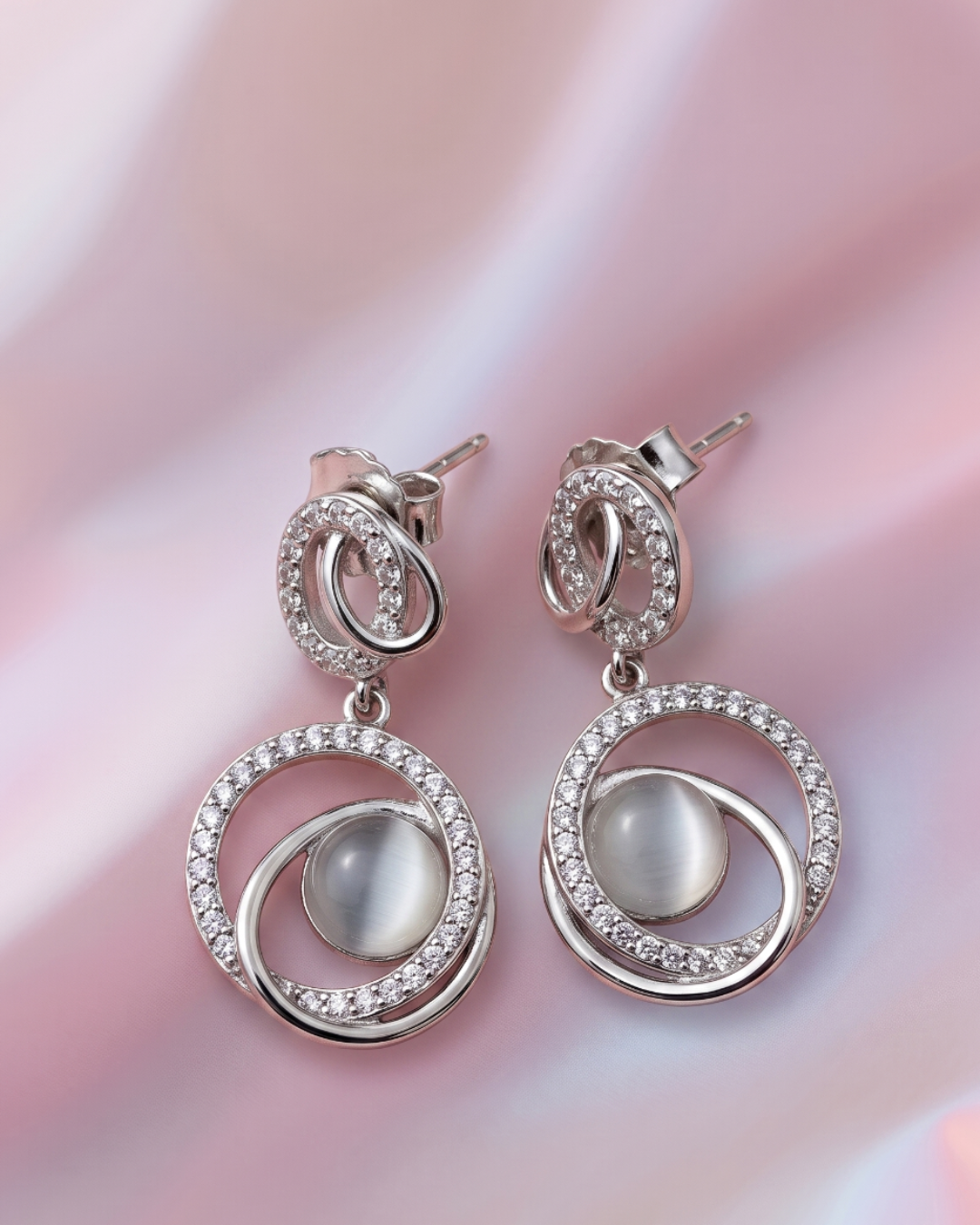 Dangle earrings with a moonstone in the centre adorned with cubic zirconia