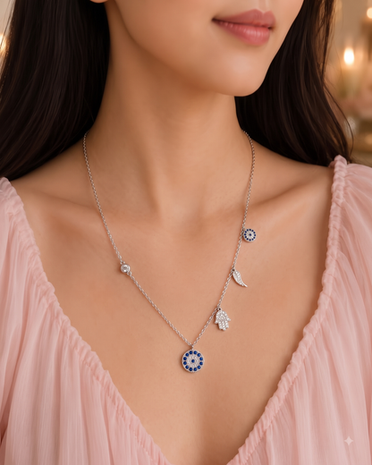 Sterling silver charm necklace featuring evil eye, hamsa hand and other luck charms