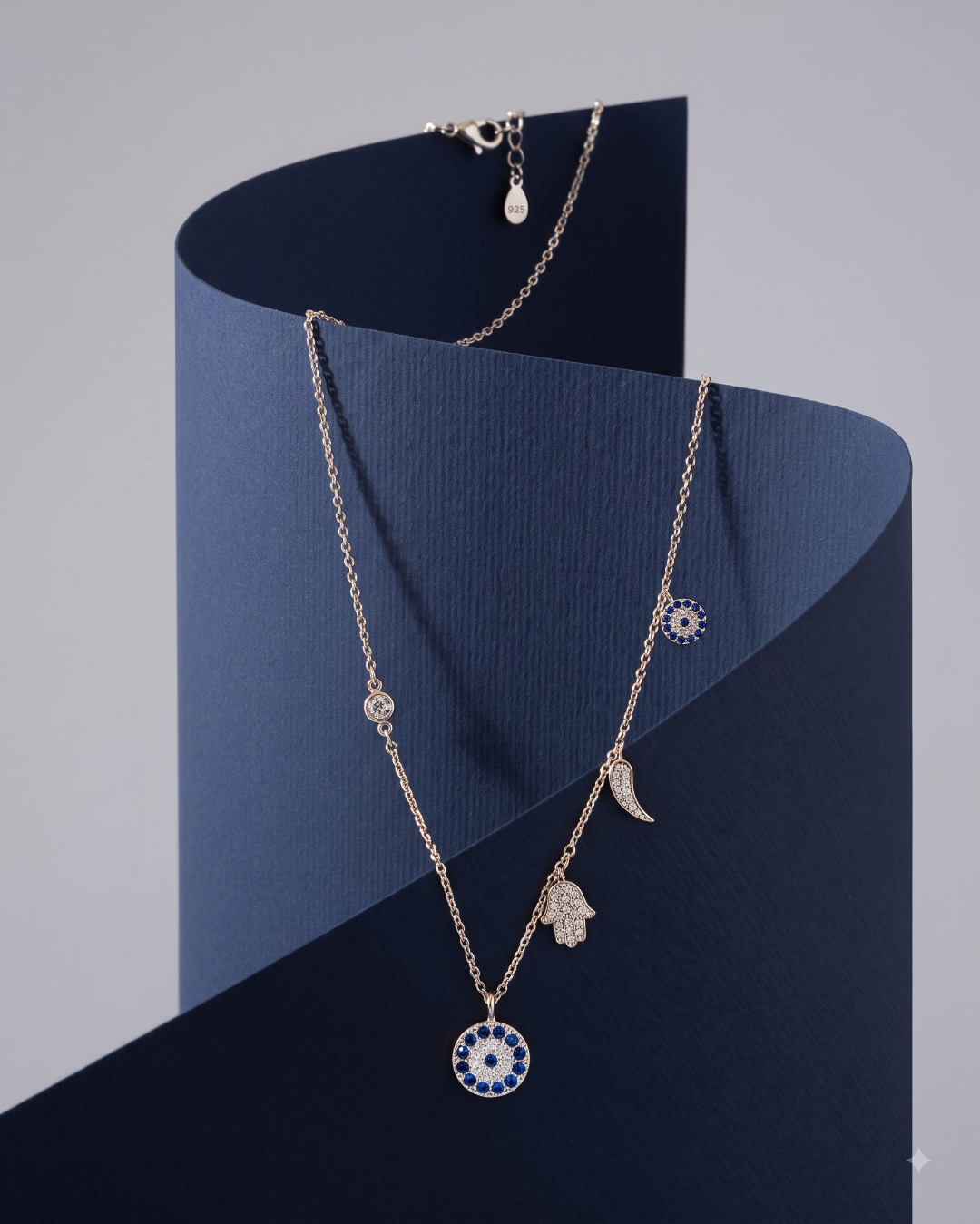 Sterling silver charm necklace featuring evil eye, hamsa hand and other luck charms