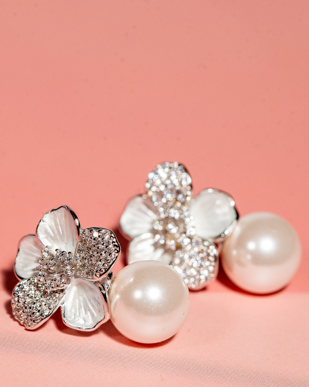 Silver toned flower and pearl drop earrings with cubic zirconia accents