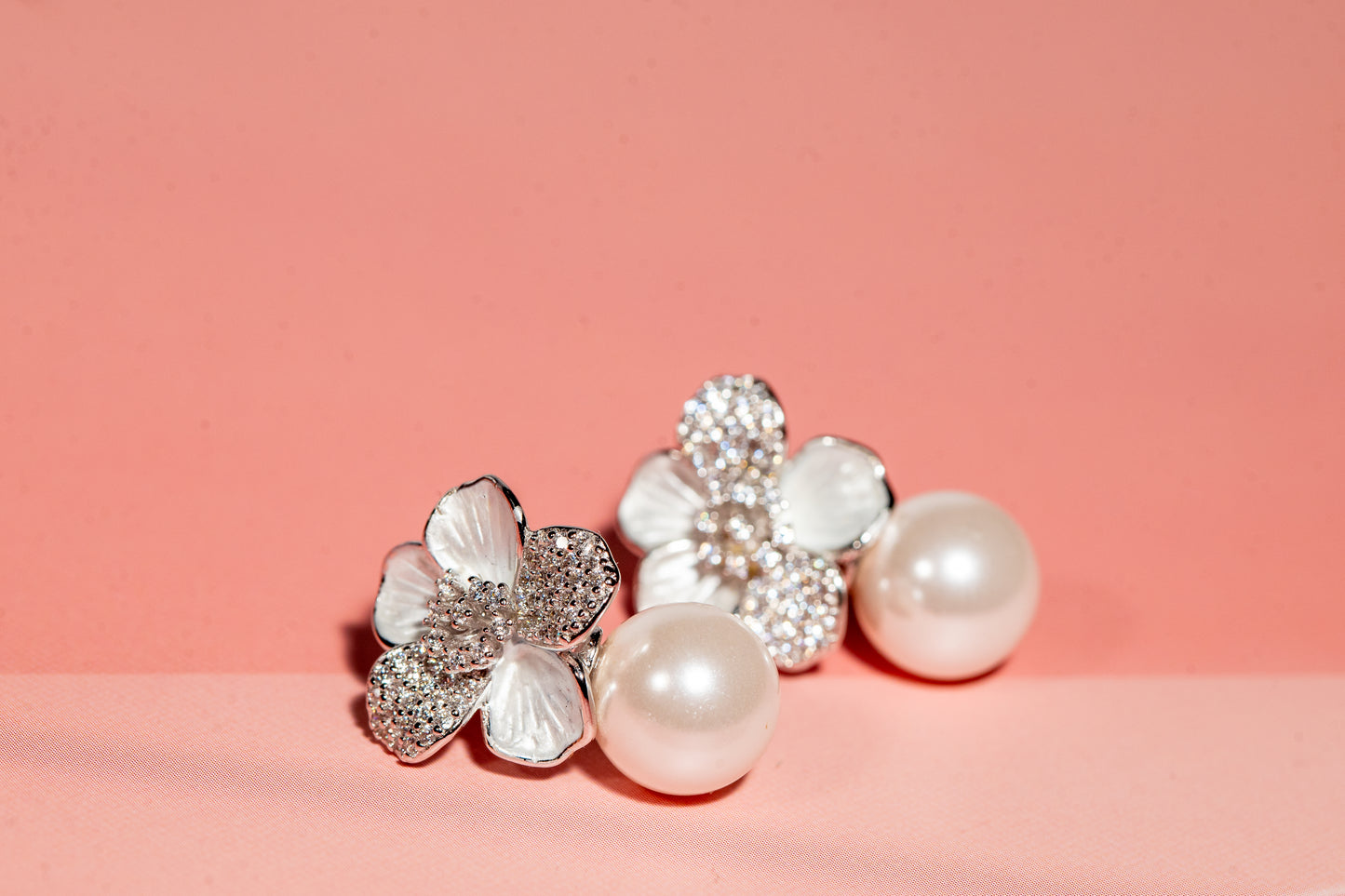 Silver toned flower and pearl drop earrings with cubic zirconia accents