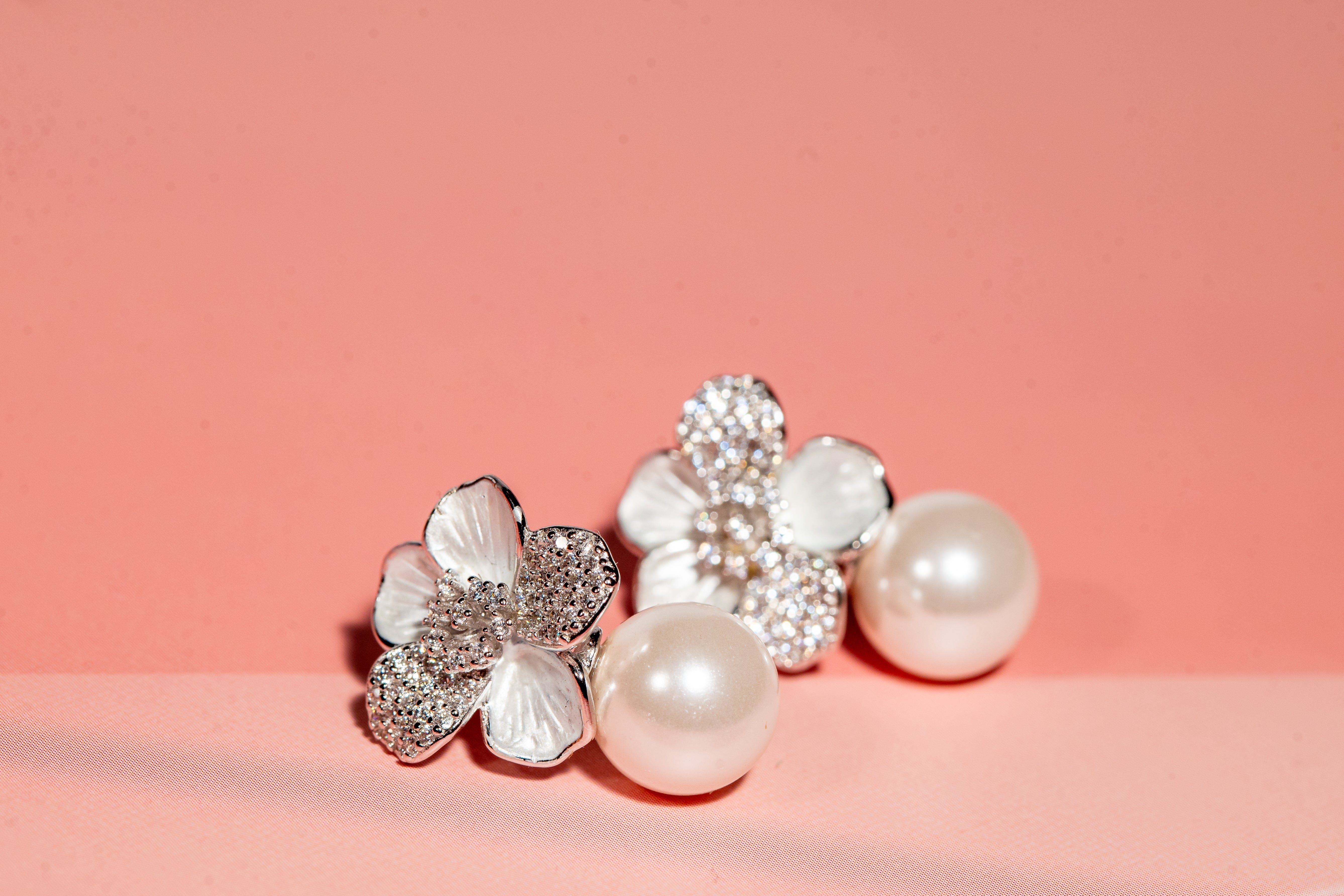 Silver toned flower and pearl drop earrings with cubic zirconia accents