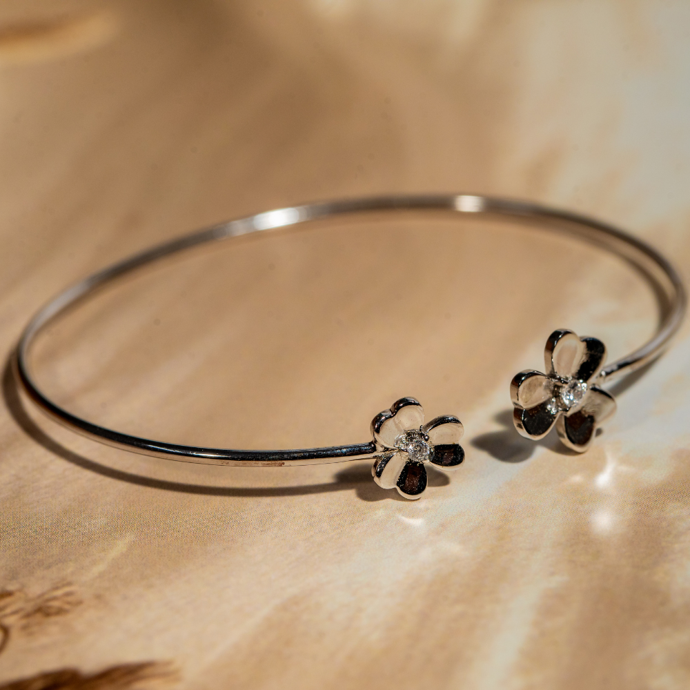 Silver tone floral design cuff bracelet with a cubic zirconia stone in the centre of the flower