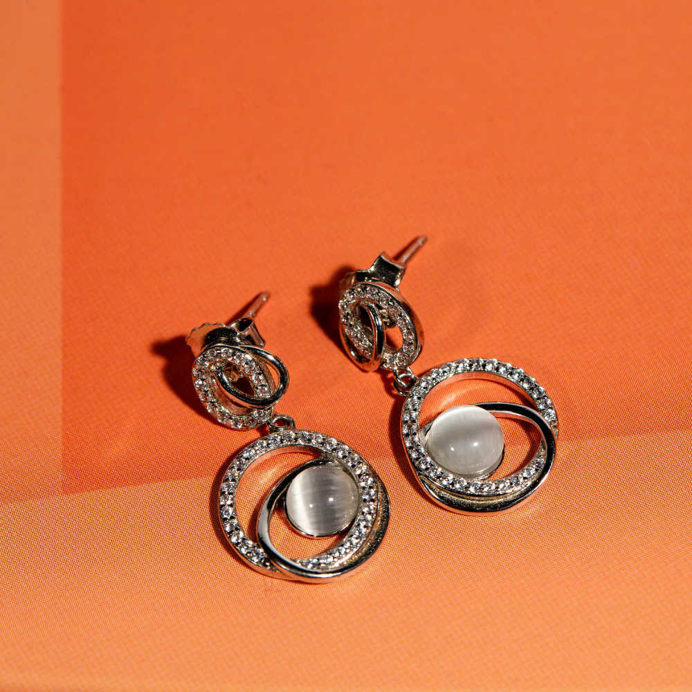 Dangle earrings with a moonstone in the centre adorned with cubic zirconia